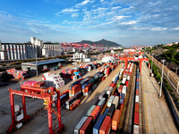 Large machinery loads containers onto a China-Europe freight train at the China-Kazakhstan (Lianyungang) logistics cooperation base in Liany...