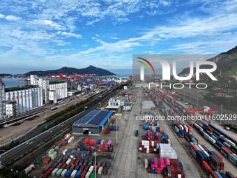 Large machinery loads containers onto a China-Europe freight train at the China-Kazakhstan (Lianyungang) logistics cooperation base in Liany...