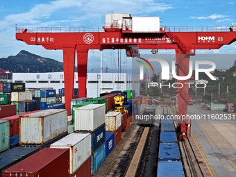 Large machinery loads containers onto a China-Europe freight train at the China-Kazakhstan (Lianyungang) logistics cooperation base in Liany...