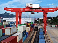 Large machinery loads containers onto a China-Europe freight train at the China-Kazakhstan (Lianyungang) logistics cooperation base in Liany...