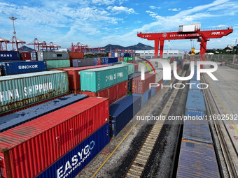 Large machinery loads containers onto a China-Europe freight train at the China-Kazakhstan (Lianyungang) logistics cooperation base in Liany...