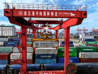 Large machinery loads containers onto a China-Europe freight train at the China-Kazakhstan (Lianyungang) logistics cooperation base in Liany...