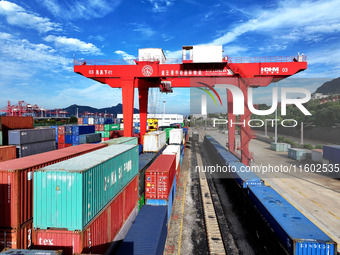 Large machinery loads containers onto a China-Europe freight train at the China-Kazakhstan (Lianyungang) logistics cooperation base in Liany...