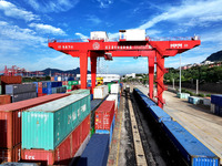 Large machinery loads containers onto a China-Europe freight train at the China-Kazakhstan (Lianyungang) logistics cooperation base in Liany...