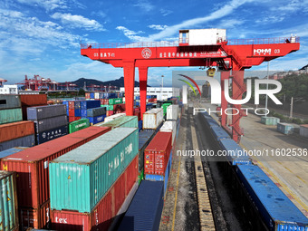 Large machinery loads containers onto a China-Europe freight train at the China-Kazakhstan (Lianyungang) logistics cooperation base in Liany...