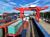 Large machinery loads containers onto a China-Europe freight train at the China-Kazakhstan (Lianyungang) logistics cooperation base in Liany...