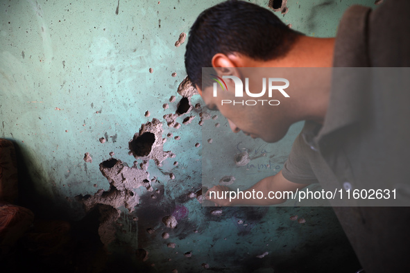 A Palestinian man inspects the damage in a room of a school sheltering displaced people after it is hit by an Israeli airstrike in the Nusei...