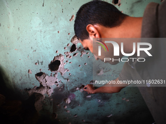 A Palestinian man inspects the damage in a room of a school sheltering displaced people after it is hit by an Israeli airstrike in the Nusei...