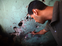 A Palestinian man inspects the damage in a room of a school sheltering displaced people after it is hit by an Israeli airstrike in the Nusei...