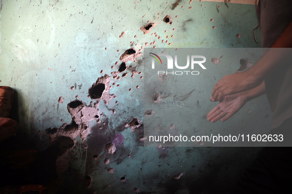 A Palestinian man inspects the damage in a room of a school sheltering displaced people after it is hit by an Israeli airstrike in the Nusei...