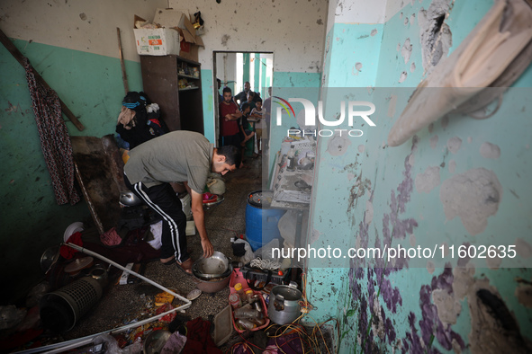 A Palestinian man inspects the damage in a room of a school sheltering displaced people after it is hit by an Israeli airstrike in the Nusei...