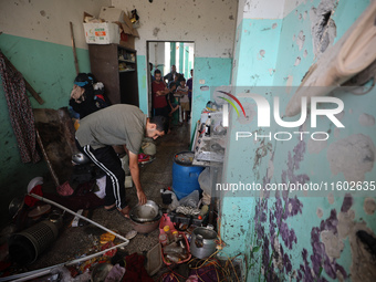 A Palestinian man inspects the damage in a room of a school sheltering displaced people after it is hit by an Israeli airstrike in the Nusei...