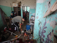 A Palestinian man inspects the damage in a room of a school sheltering displaced people after it is hit by an Israeli airstrike in the Nusei...