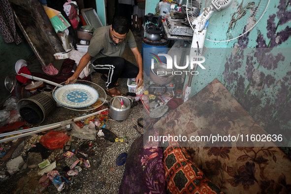 A Palestinian man inspects the damage in a room of a school sheltering displaced people after it is hit by an Israeli airstrike in the Nusei...