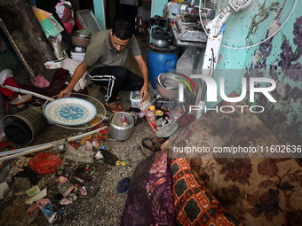 A Palestinian man inspects the damage in a room of a school sheltering displaced people after it is hit by an Israeli airstrike in the Nusei...