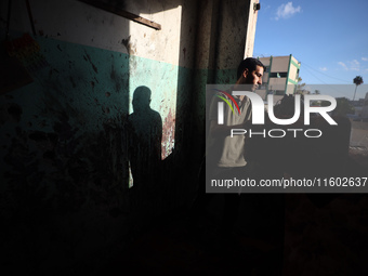 A Palestinian man inspects the damage in a room of a school sheltering displaced people after it is hit by an Israeli airstrike in the Nusei...