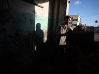 A Palestinian man inspects the damage in a room of a school sheltering displaced people after it is hit by an Israeli airstrike in the Nusei...