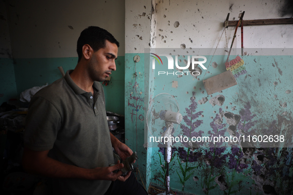 A Palestinian man inspects the damage in a room of a school sheltering displaced people after it is hit by an Israeli airstrike in the Nusei...