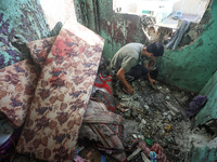 A Palestinian man inspects the damage in a room of a school sheltering displaced people after it is hit by an Israeli airstrike in the Nusei...