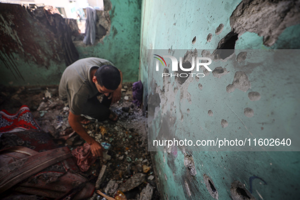 A Palestinian man inspects the damage in a room of a school sheltering displaced people after it is hit by an Israeli airstrike in the Nusei...