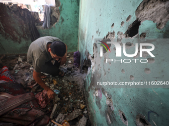 A Palestinian man inspects the damage in a room of a school sheltering displaced people after it is hit by an Israeli airstrike in the Nusei...