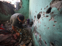 A Palestinian man inspects the damage in a room of a school sheltering displaced people after it is hit by an Israeli airstrike in the Nusei...