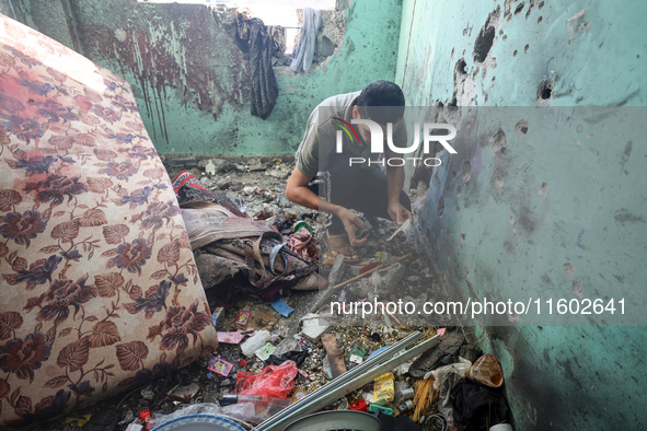 A Palestinian man inspects the damage in a room of a school sheltering displaced people after it is hit by an Israeli airstrike in the Nusei...