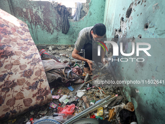 A Palestinian man inspects the damage in a room of a school sheltering displaced people after it is hit by an Israeli airstrike in the Nusei...