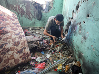 A Palestinian man inspects the damage in a room of a school sheltering displaced people after it is hit by an Israeli airstrike in the Nusei...