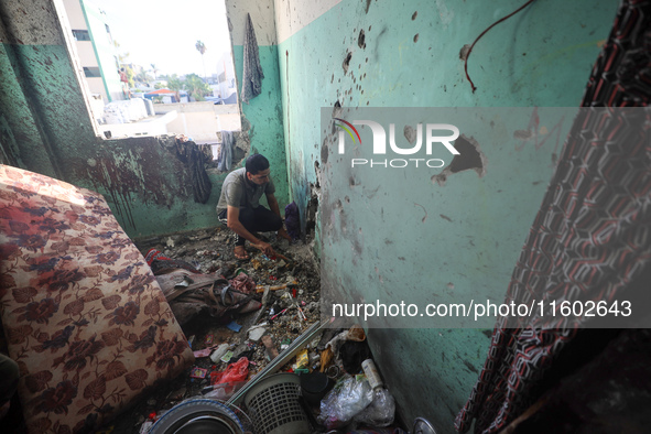 A Palestinian man inspects the damage in a room of a school sheltering displaced people after it is hit by an Israeli airstrike in the Nusei...