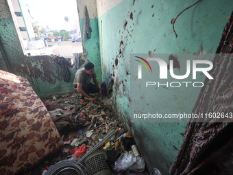 A Palestinian man inspects the damage in a room of a school sheltering displaced people after it is hit by an Israeli airstrike in the Nusei...