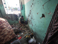 A Palestinian man inspects the damage in a room of a school sheltering displaced people after it is hit by an Israeli airstrike in the Nusei...