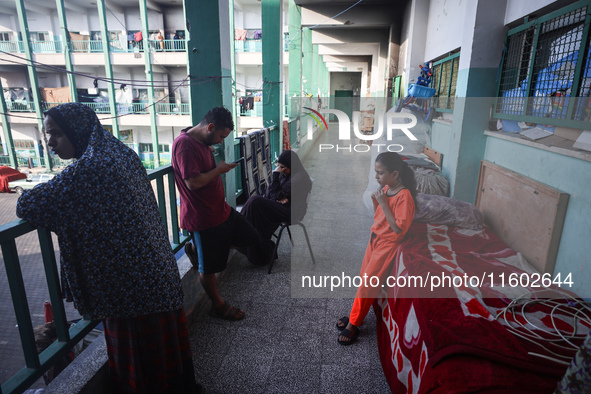 Palestinians stand at a school sheltering displaced people after an Israeli air strike hits the site in Nuseirat, Gaza Strip, on September 2...