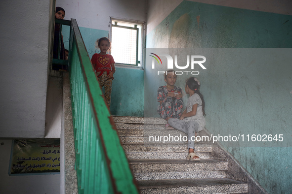 Palestinians stand at a school sheltering displaced people after an Israeli air strike hits the site in Nuseirat, Gaza Strip, on September 2...