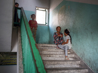 Palestinians stand at a school sheltering displaced people after an Israeli air strike hits the site in Nuseirat, Gaza Strip, on September 2...