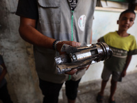 A Palestinian man inspects the damage in a room of a school sheltering displaced people after it is hit by an Israeli airstrike in the Nusei...