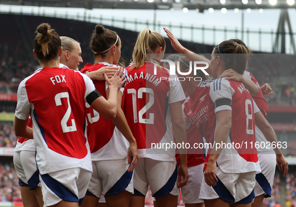 Players gather to celebrate Arsenal's opening goal during the Barclays FA Women's Super League match between Arsenal and Manchester City at...