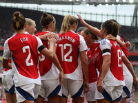 Players gather to celebrate Arsenal's opening goal during the Barclays FA Women's Super League match between Arsenal and Manchester City at...