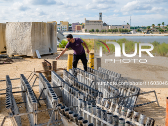 A technician inserts the bombs into the mortar for the preparation of the fireworks display at the New Port under construction in Molfetta,...