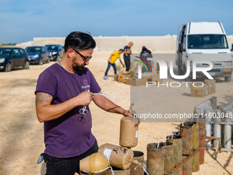 A technician inserts the bombs into the mortar for the preparation of the fireworks display at the New Port under construction in Molfetta,...