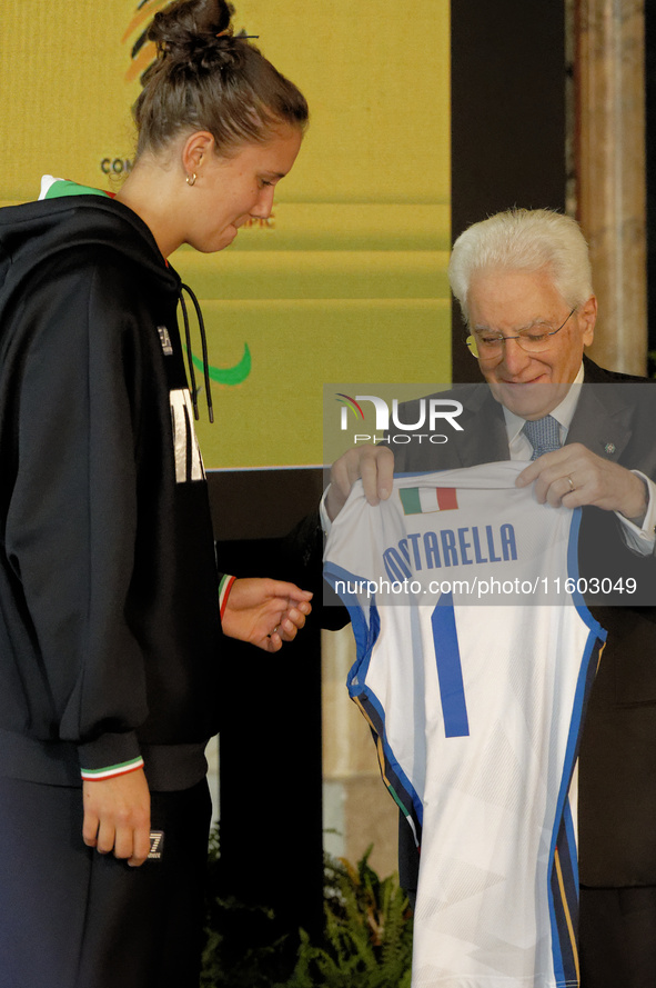 Sergio Mattarella receives a volleyball shirt dedicated to him from Anna Danesi during the return ceremony of the Flag of the Italian athlet...