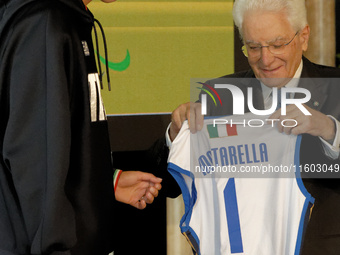 Sergio Mattarella receives a volleyball shirt dedicated to him from Anna Danesi during the return ceremony of the Flag of the Italian athlet...