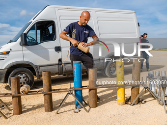 A technician inserts the bombs into the mortar for the preparation of the fireworks display at the New Port under construction in Molfetta,...