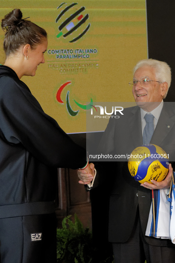 Sergio Mattarella receives a volleyball shirt dedicated to him from Anna Danesi during the return ceremony of the Flag of the Italian athlet...