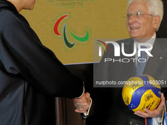 Sergio Mattarella receives a volleyball shirt dedicated to him from Anna Danesi during the return ceremony of the Flag of the Italian athlet...