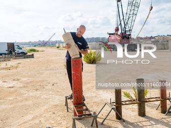 A technician inserts the bombs into the mortar for the preparation of the fireworks display at the New Port under construction in Molfetta,...