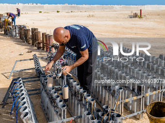 A technician inserts the bombs into the mortar for the preparation of the fireworks display at the New Port under construction in Molfetta,...