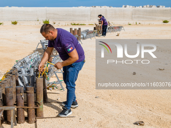 A technician inserts the bombs into the mortar for the preparation of the fireworks display at the New Port under construction in Molfetta,...