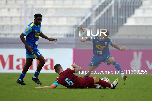 In Ta' Qali, Malta, on September 21, 2024, Zachary Scerri (center) of Gzira United competes for the ball with Myles Beerman (right) of Sliem...