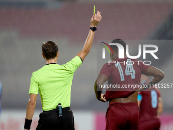 In Ta' Qali, Malta, on September 21, 2024, Malta FA-appointed match referee Alex Johnson (L) shows the yellow card to Luis Carlo Riascos (R)...